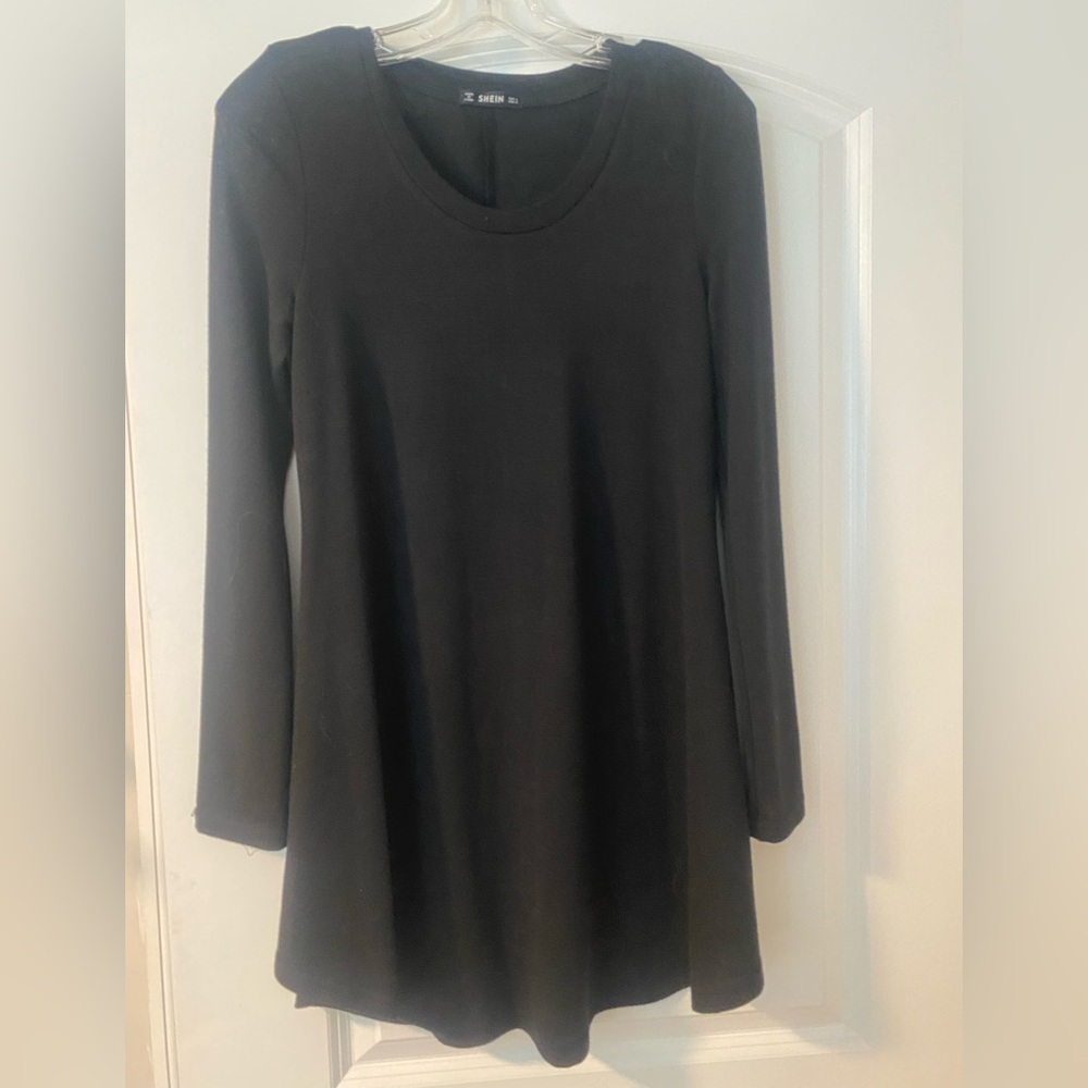 Short black knit dress with long sleeves. Top is tighter with a flowy bottom.